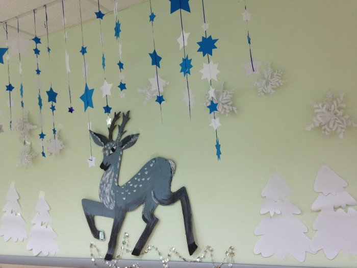 Украшенный новогодний зал в детском саду с лошадкой качалкой