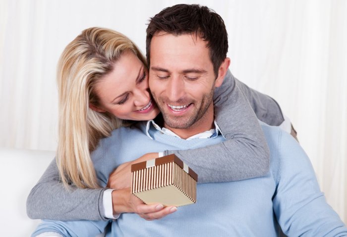 Девушка дарит подарок мужчине