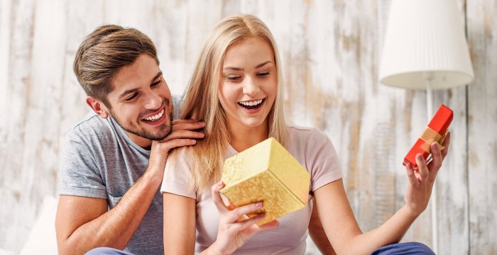 Девушка дарит подарок мужчине