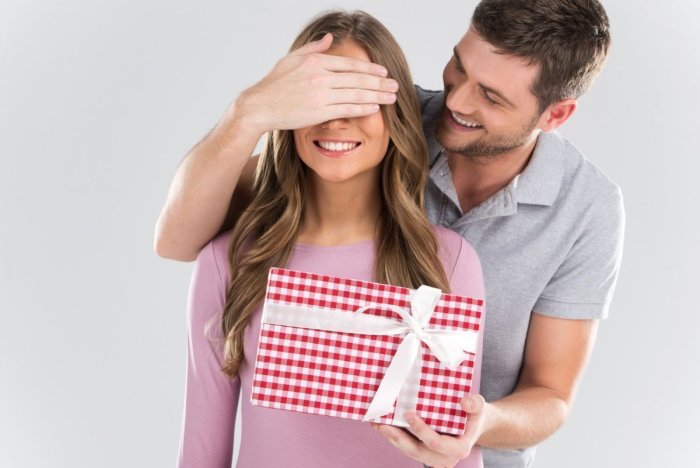 Девушка дарит подарок мужчине