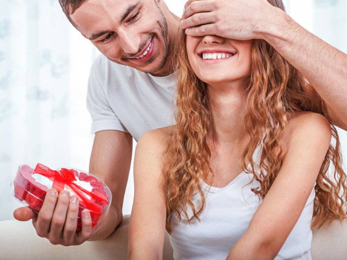 Девушка дарит подарок мужчине
