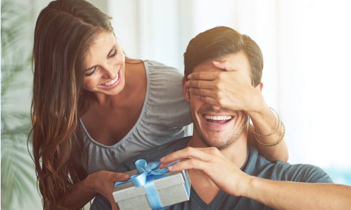 Девушка дарит подарок мужчине