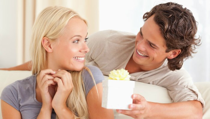 Девушка дарит подарок парню на улице